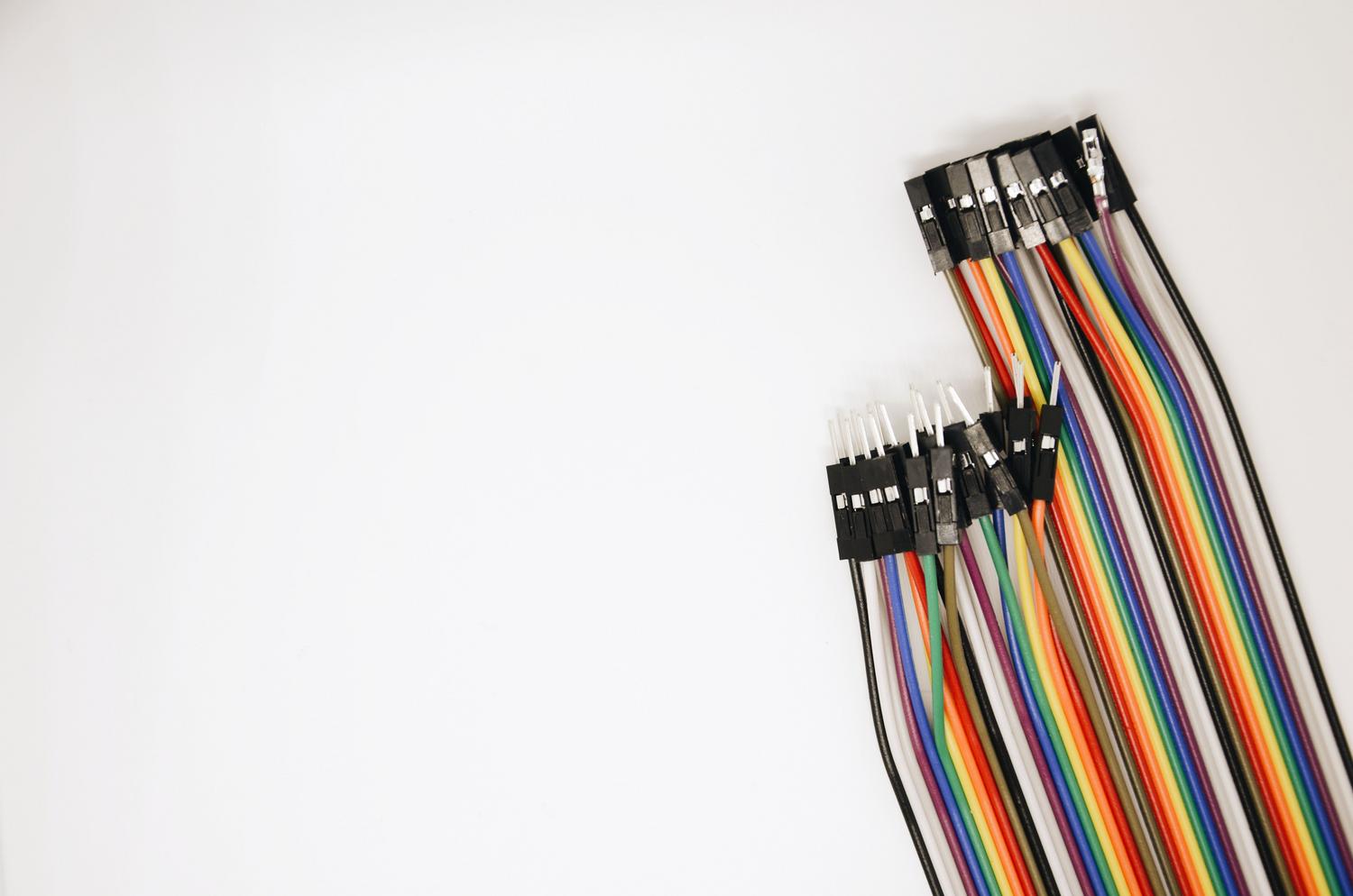 Set de cables jumper de colores para prototipado electrónico sobre fondo blanco