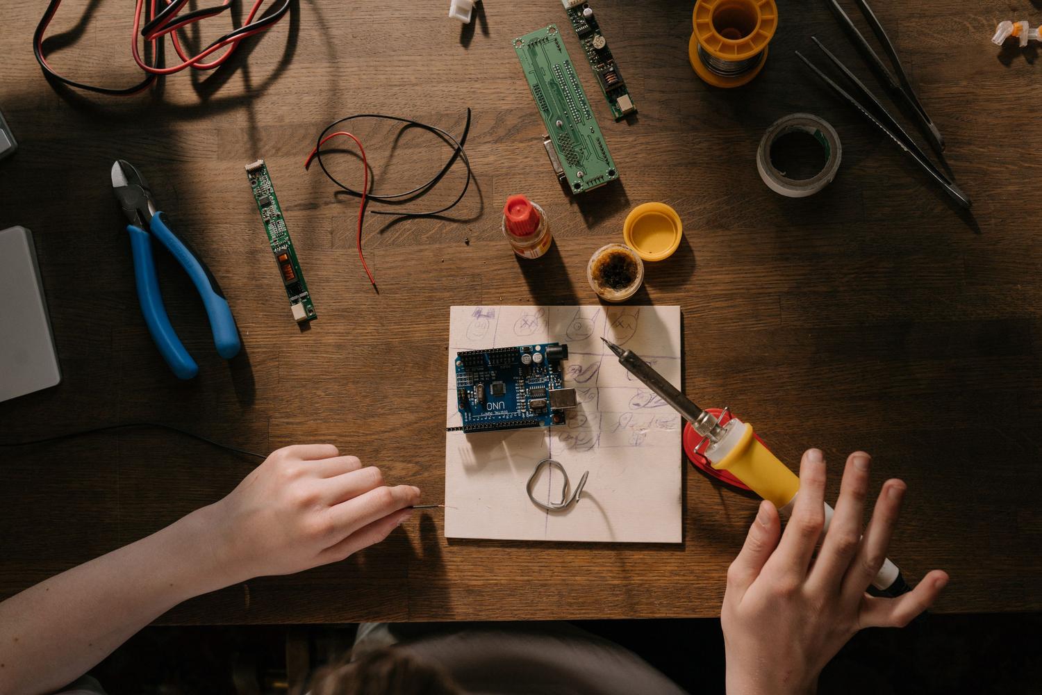 Espacio de trabajo de electrónica con herramientas de soldadura y placas de circuito
