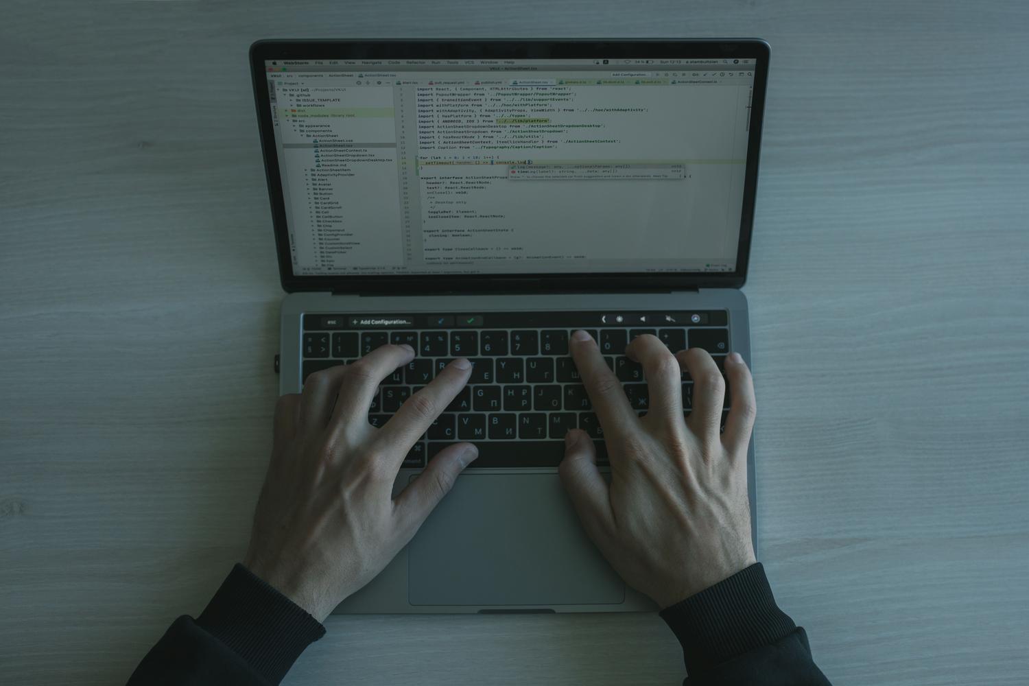 Primer plano de las manos de un desarrollador escribiendo código en un teclado, simbolizando la fase de programación y configuración.