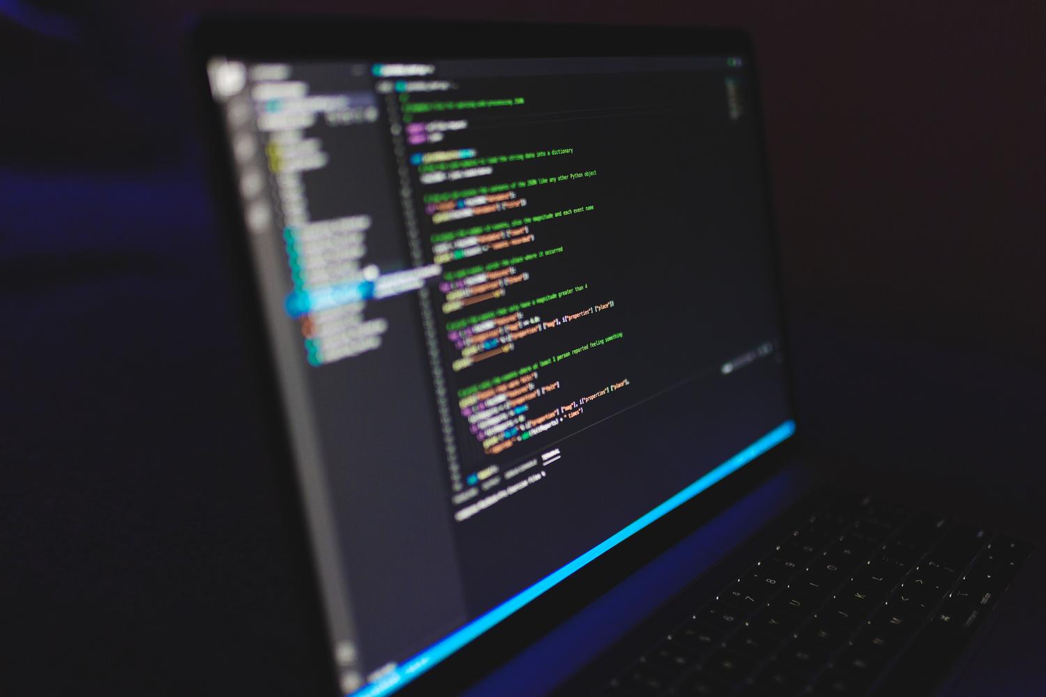 Entorno de programación en modo oscuro en un ordenador portátil, representando la atmósfera de desarrollo de software.