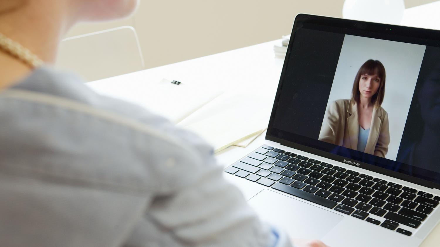 Primer plano de una mujer profesional en una videollamada coordinando tareas laborales.