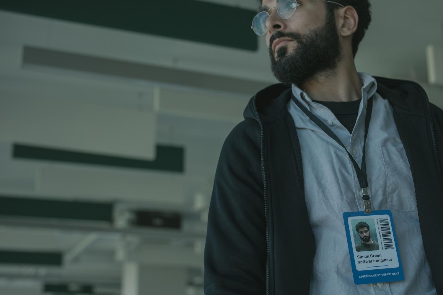 Profesional de TI con credencial de identificación en una oficina moderna, simbolizando la certificación profesional.