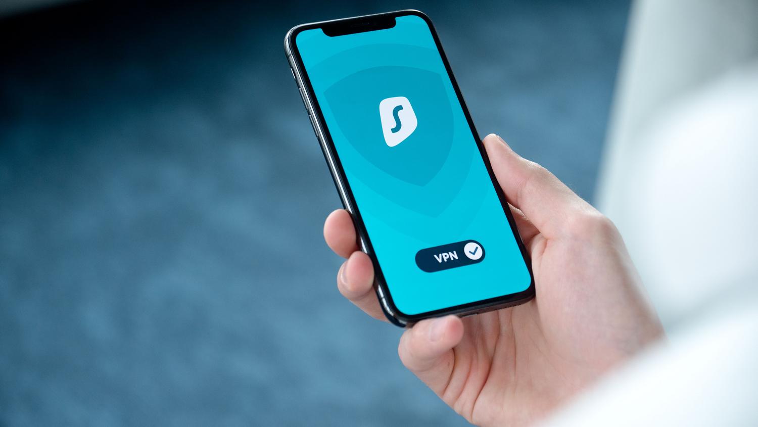 Mano sosteniendo un smartphone que muestra una interfaz de aplicación de seguridad para una navegación blindada.